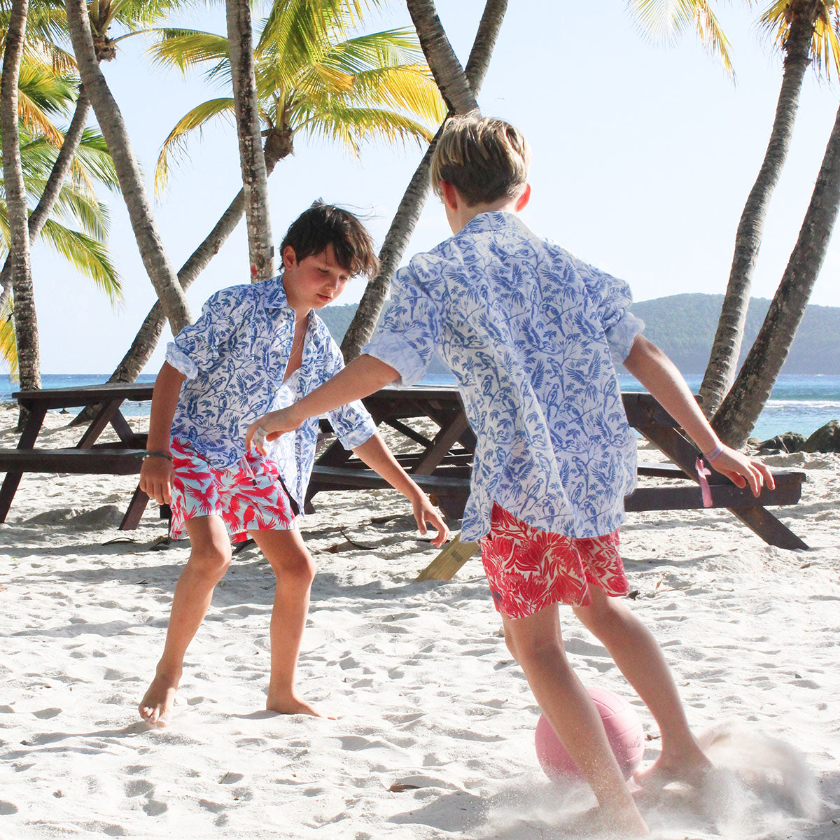 Kids fun beach swim shorts in turquoise blue and coral red Striped Shell print by designer Lotty B