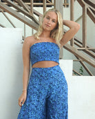 Luxury resortwear silk shirred bandeau top in blue floral Flamboyant Flower print with matching palazzo pants by designer Lotty B Mustique