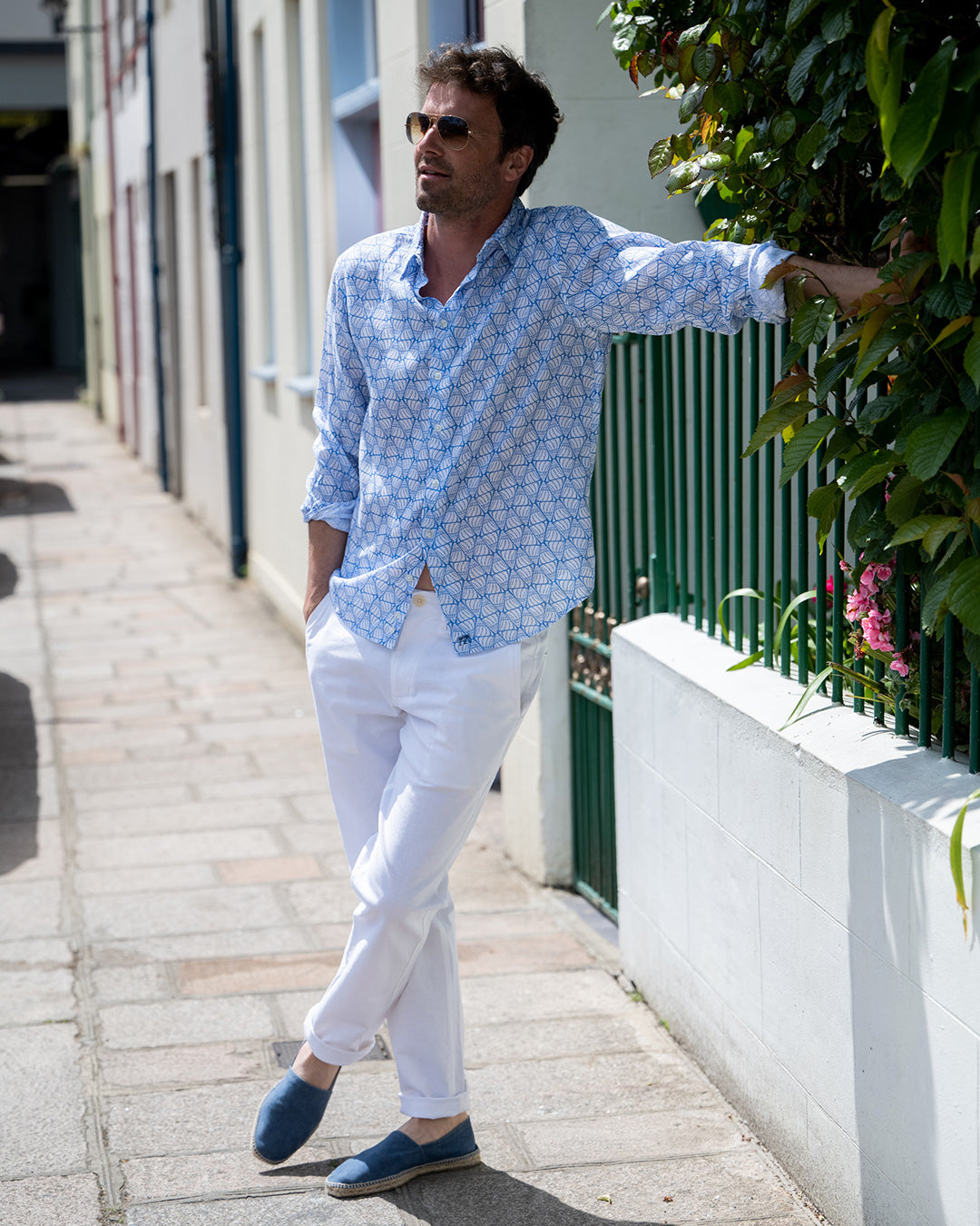 Classic white comfortable stretch linen pants worn with blue shelltop linen shirt. Designer linen resortwear by Pink House 