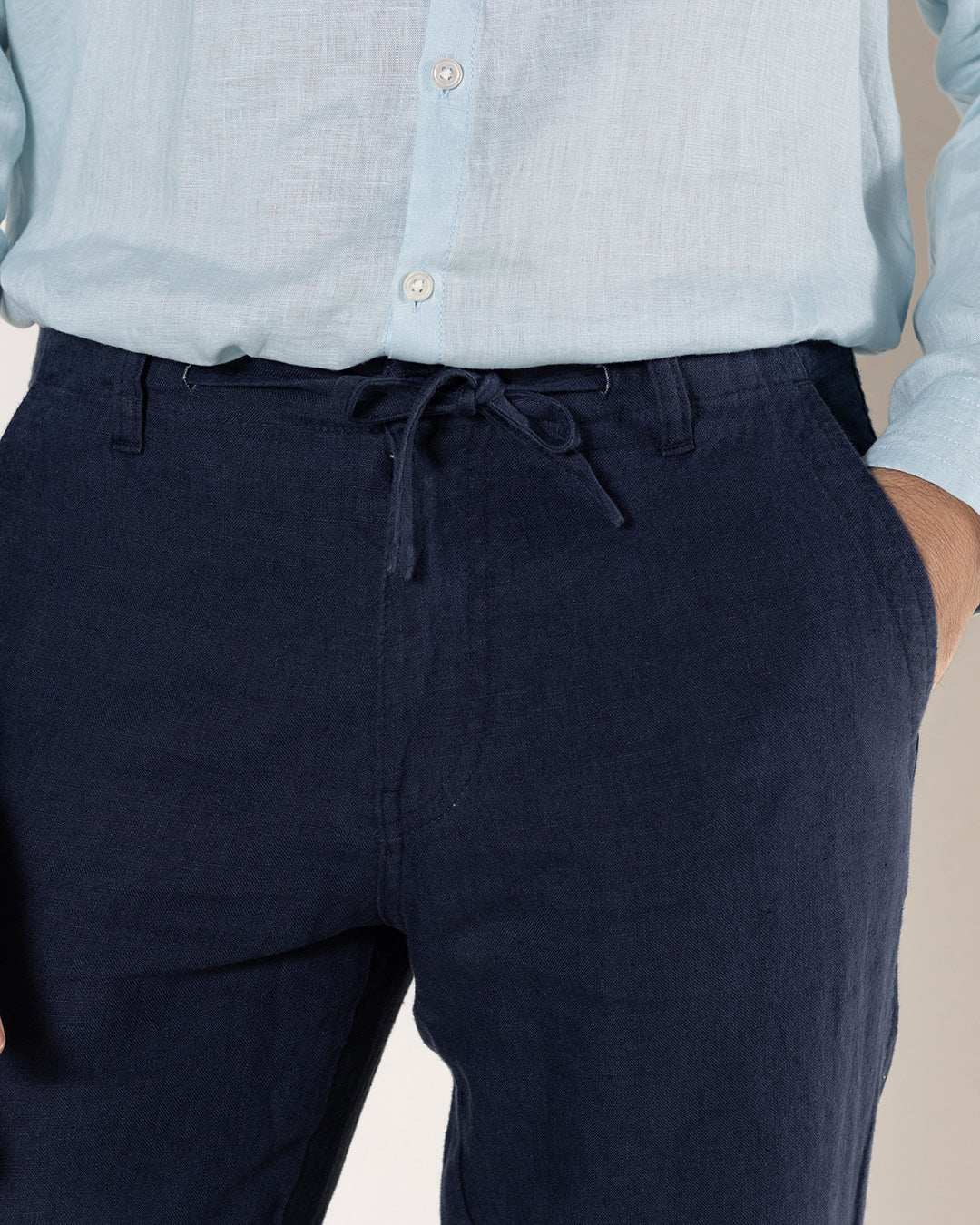 Men's comfy vacation linen pants in eclipse navy blue worn with pale blue linen shirt