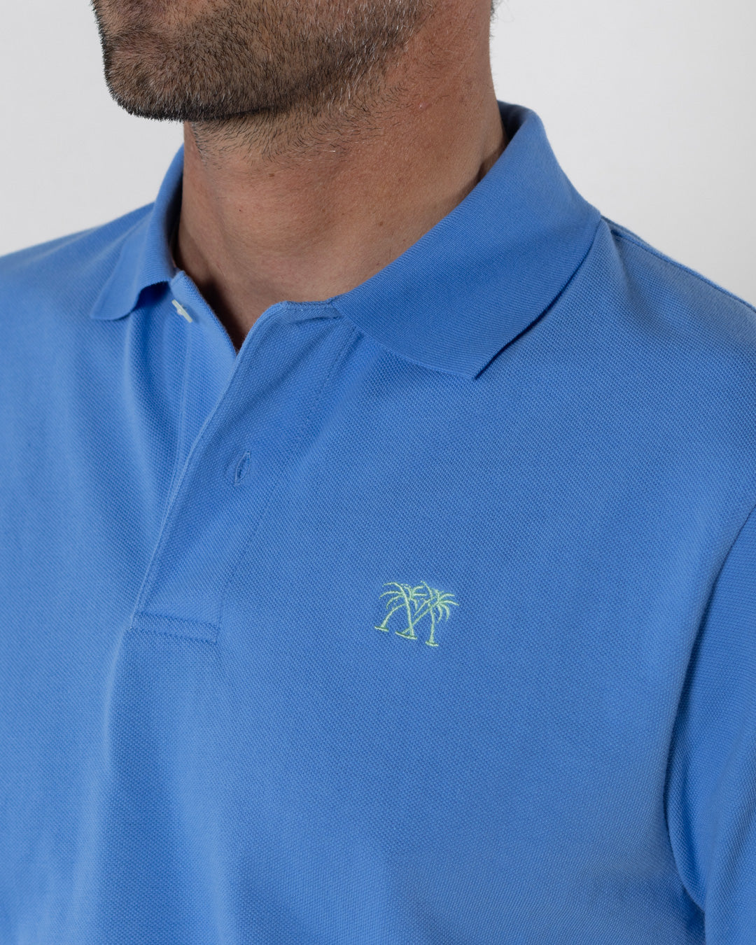 Mens premium pure cotton mid blue polo shirt with bright green Pink House logo embroidery